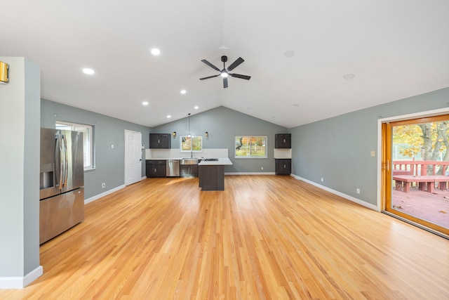 unfurnished living room featuring light wood-type flooring, vaulted ceiling, and ceiling fan