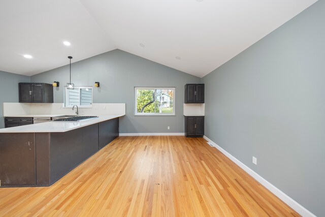 5731 Farmington Rd, West Bloomfield, MI 48322 - kitchen featuring light wood finished floors, light countertops, lofted ceiling, a peninsula, and a sink