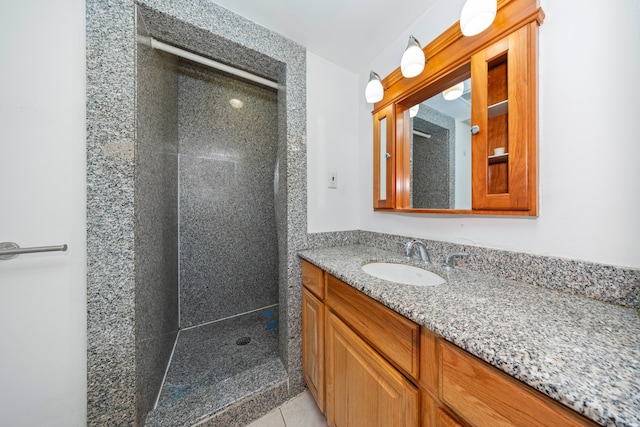 bathroom with a tile shower, tile patterned floors, and vanity