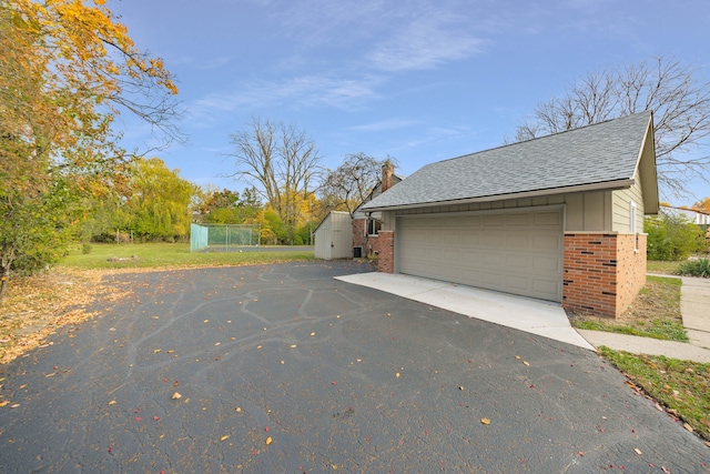 view of side of property with a garage and a storage unit