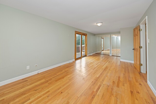 5731 Farmington Rd, West Bloomfield, MI 48322 - unfurnished bedroom with access to exterior, light wood-style floors, and baseboards
