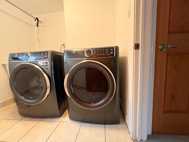 5731 Farmington Rd, West Bloomfield, MI 48322 - washroom with washing machine and clothes dryer, light tile patterned floors, and baseboards