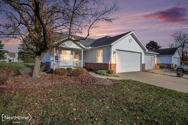 ranch-style home featuring a yard, covered porch, and a garage