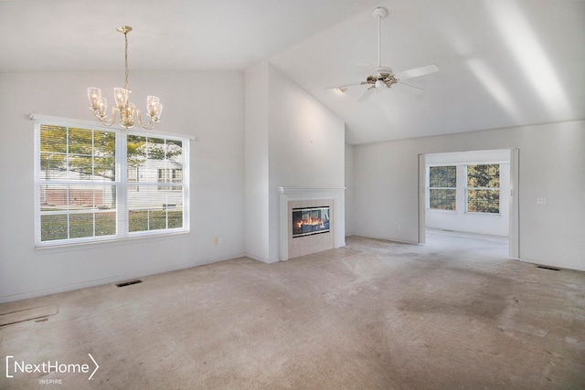 unfurnished living room with a wealth of natural light, a fireplace, light carpet, and ceiling fan with notable chandelier