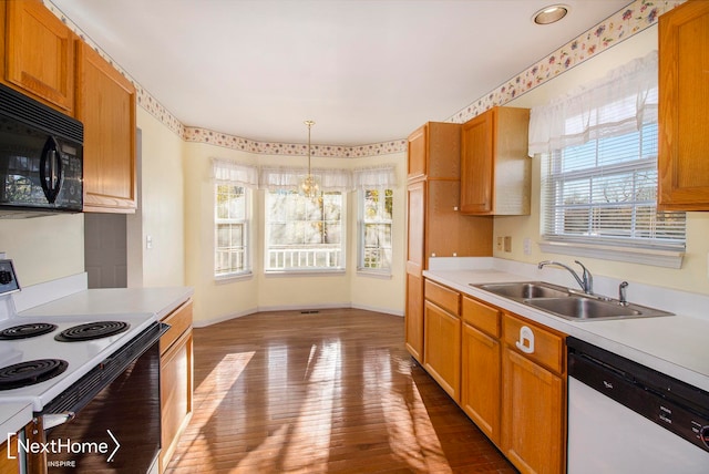 kitchen featuring sink, dishwasher, hanging light fixtures, white electric stove, and light hardwood / wood-style floors