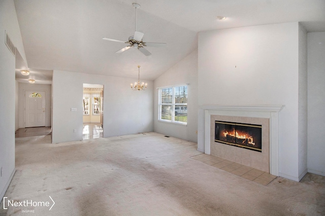 unfurnished living room with a tile fireplace, light carpet, high vaulted ceiling, and ceiling fan with notable chandelier