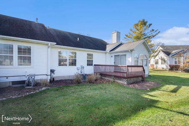 back of house featuring a lawn and a deck