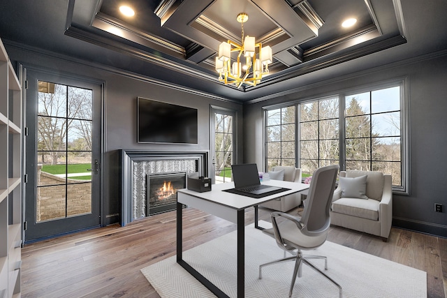 home office featuring wood-type flooring, an inviting chandelier, a wealth of natural light, and ornamental molding