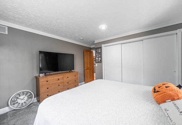 carpeted bedroom featuring a textured ceiling, a closet, and ornamental molding