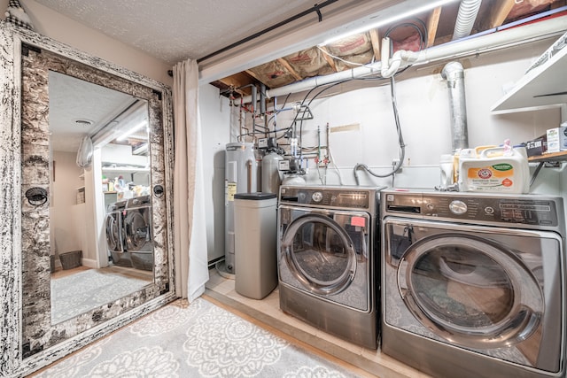 clothes washing area with washer and dryer and a textured ceiling