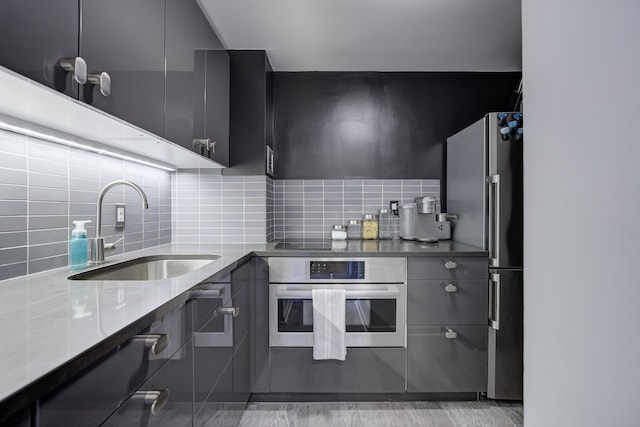 kitchen featuring decorative backsplash, sink, dark stone counters, and appliances with stainless steel finishes