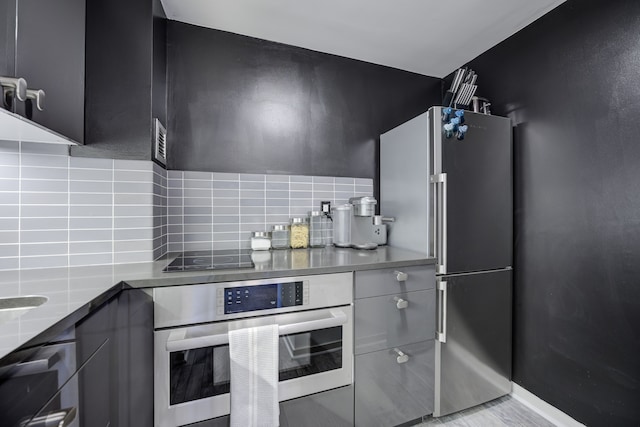 kitchen featuring stainless steel appliances and tasteful backsplash