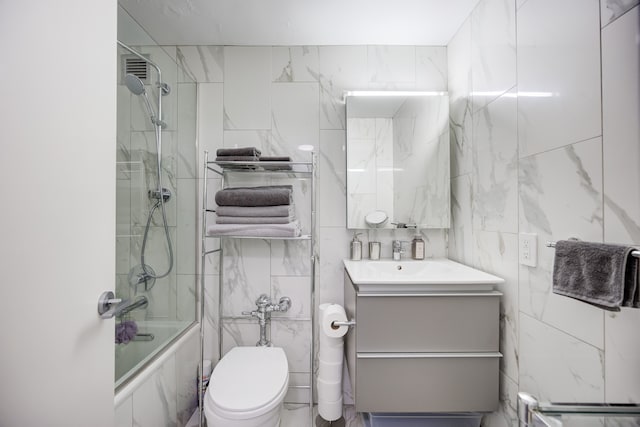 full bathroom featuring vanity, toilet, tile walls, and bath / shower combo with glass door