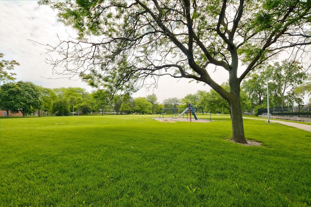 view of property's community featuring a playground and a lawn