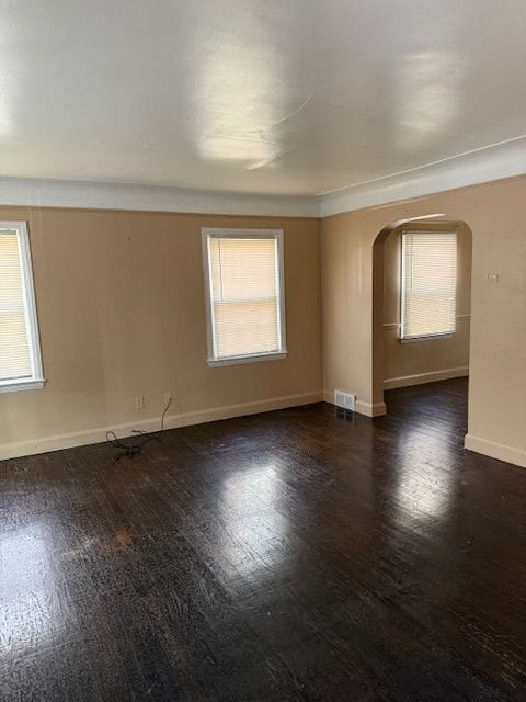 unfurnished room featuring dark hardwood / wood-style flooring and plenty of natural light