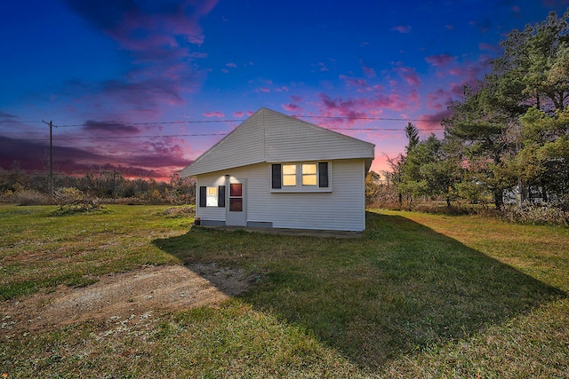 property exterior at dusk with a lawn