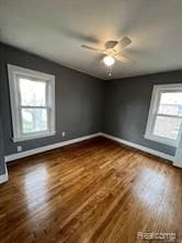 spare room featuring ceiling fan and dark wood-type flooring