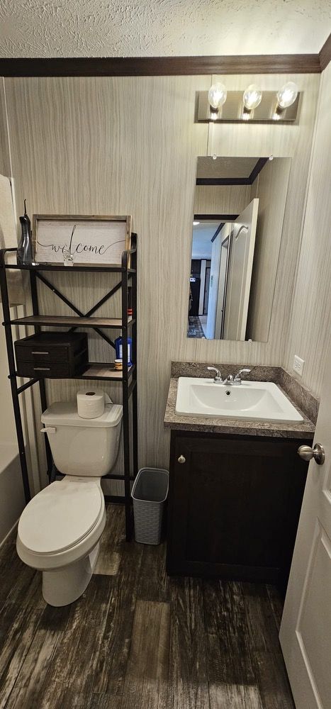 bathroom with toilet, vanity, and hardwood / wood-style flooring