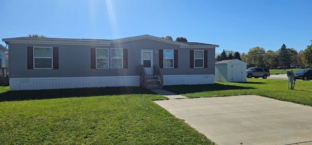 manufactured / mobile home with a front yard and a storage shed