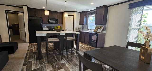 kitchen featuring black appliances, a healthy amount of sunlight, dark brown cabinetry, and hanging light fixtures