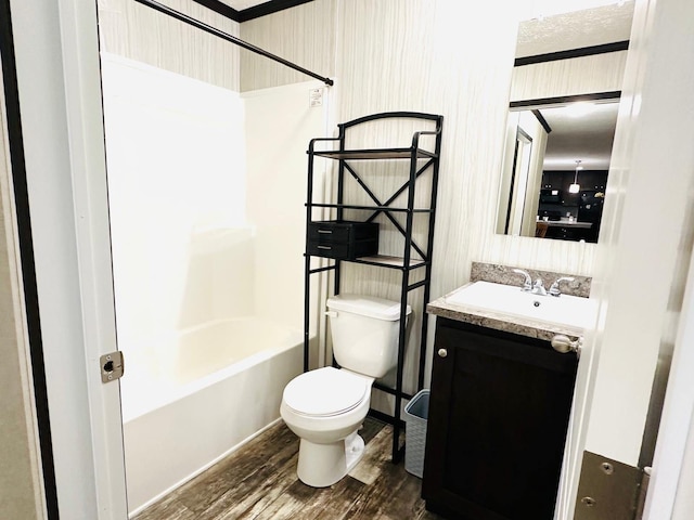 full bathroom with toilet, vanity,  shower combination, and hardwood / wood-style flooring