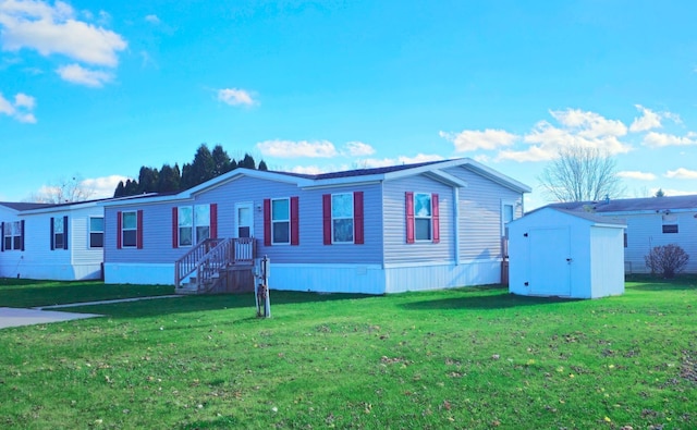 manufactured / mobile home featuring a front yard and a storage shed