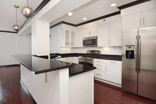 kitchen featuring dark wood-type flooring, white cabinets, decorative light fixtures, kitchen peninsula, and stainless steel appliances