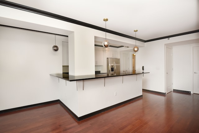 kitchen featuring dark wood-type flooring, white cabinets, kitchen peninsula, decorative light fixtures, and stainless steel fridge with ice dispenser