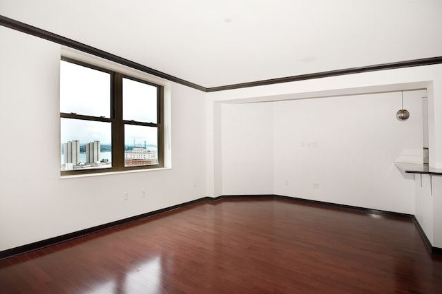 unfurnished room featuring dark hardwood / wood-style floors and crown molding