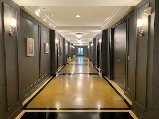 hallway featuring crown molding and light tile patterned flooring