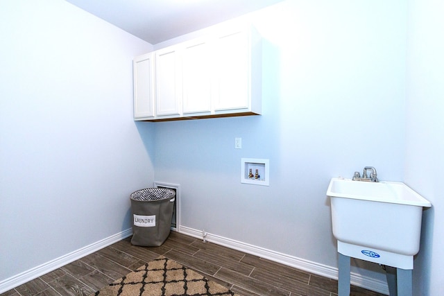 laundry room with hookup for a washing machine, dark hardwood / wood-style flooring, cabinets, and sink