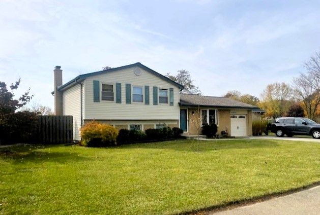 split level home featuring a garage and a front lawn