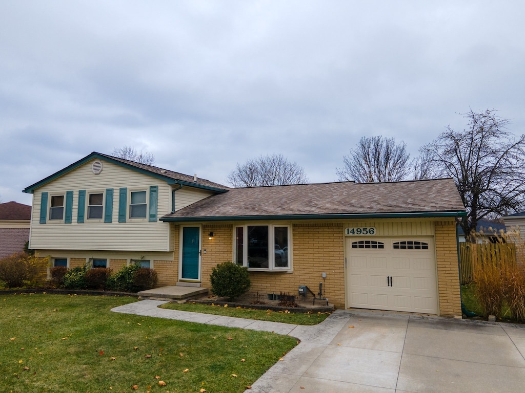 split level home with a garage and a front lawn