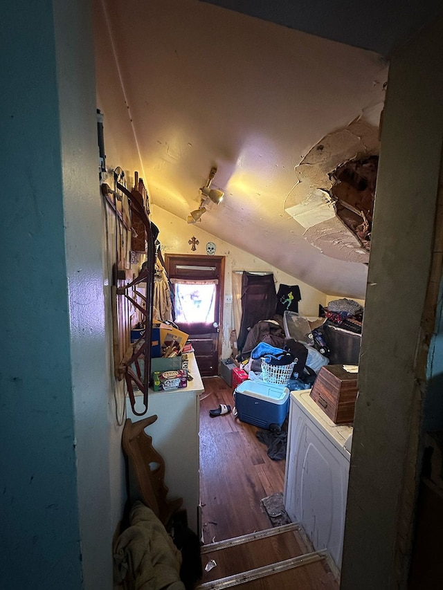 bonus room featuring wood-type flooring, washer / dryer, and vaulted ceiling