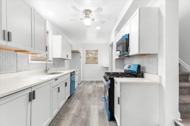 kitchen with white cabinetry, sink, gas range oven, and light hardwood / wood-style flooring