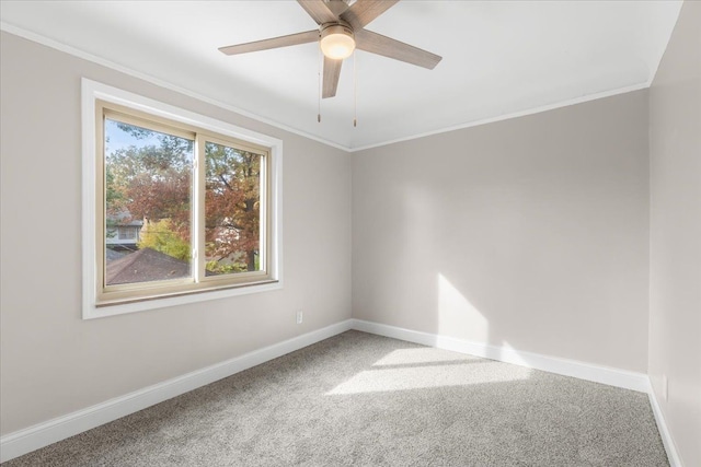 carpeted empty room with ceiling fan and crown molding