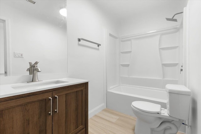 full bathroom with hardwood / wood-style floors, vanity, shower / bathtub combination, and toilet