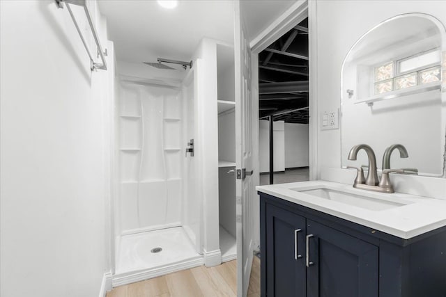 bathroom with vanity, hardwood / wood-style flooring, and walk in shower