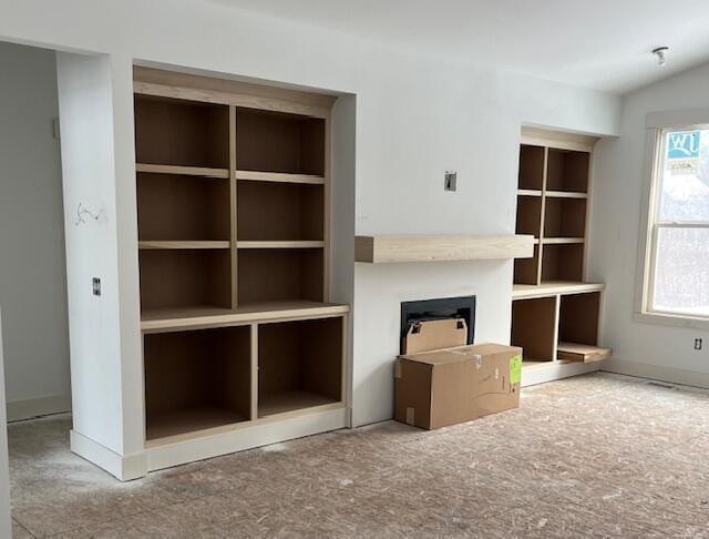 unfurnished living room featuring lofted ceiling