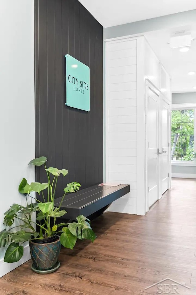 mudroom with hardwood / wood-style floors and wooden walls