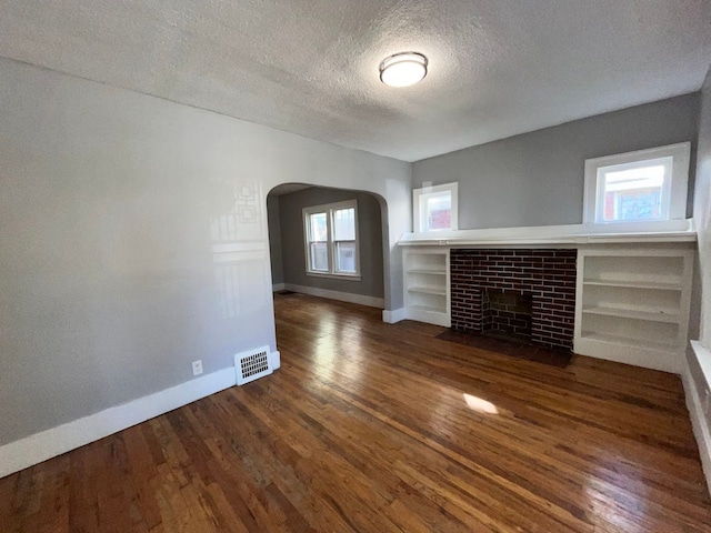 unfurnished living room with dark hardwood / wood-style flooring and a healthy amount of sunlight