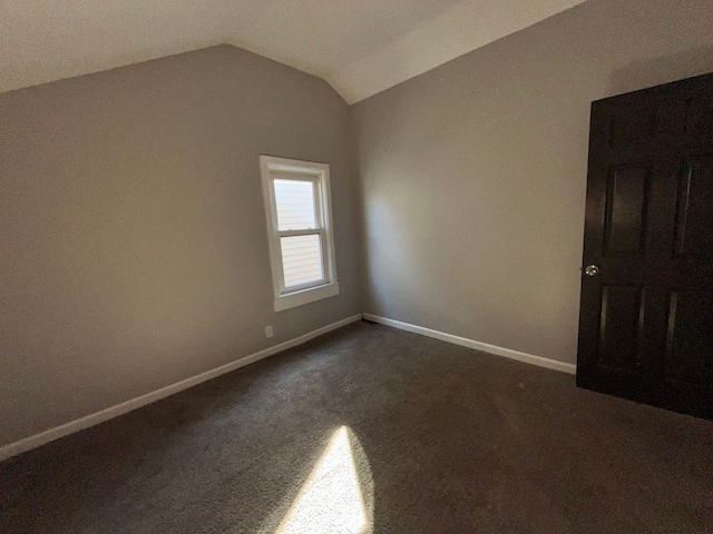 carpeted spare room with lofted ceiling