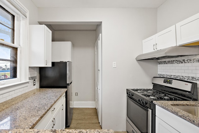 kitchen featuring decorative backsplash, appliances with stainless steel finishes, and white cabinetry