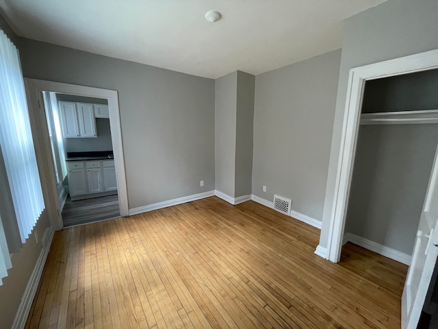 unfurnished bedroom featuring a closet and hardwood / wood-style floors