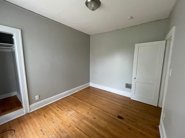 unfurnished bedroom with a closet and hardwood / wood-style floors