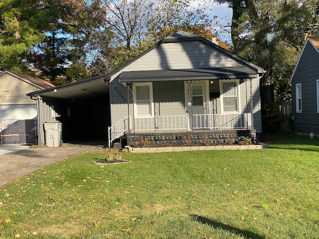 bungalow featuring a porch, a front yard, and a carport