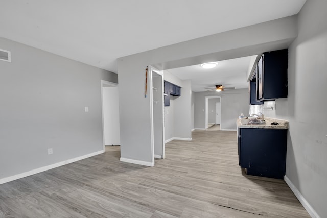 unfurnished living room with ceiling fan, hardwood / wood-style floors, and sink