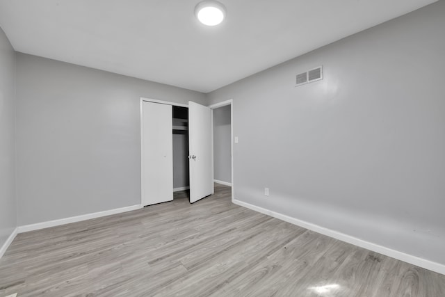 unfurnished bedroom with a closet and light hardwood / wood-style flooring