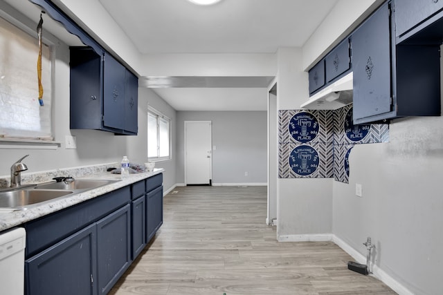 kitchen featuring blue cabinetry, dishwasher, sink, and light wood-type flooring