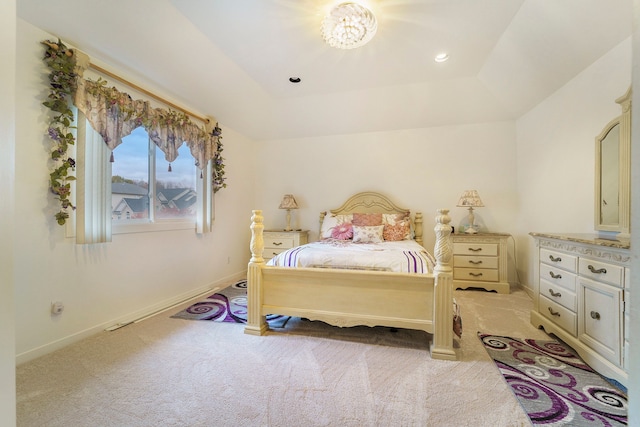 bedroom featuring a raised ceiling and light colored carpet